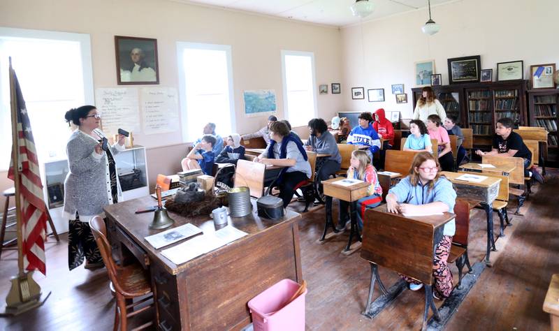 Museum Director Amanda Carter shares the history of Aitken School with Bureau County Special Schools BEST Program students on Tuesday, May 20, 2025, at the La Salle County Historical Society's one-room schoolhouse in Utica.