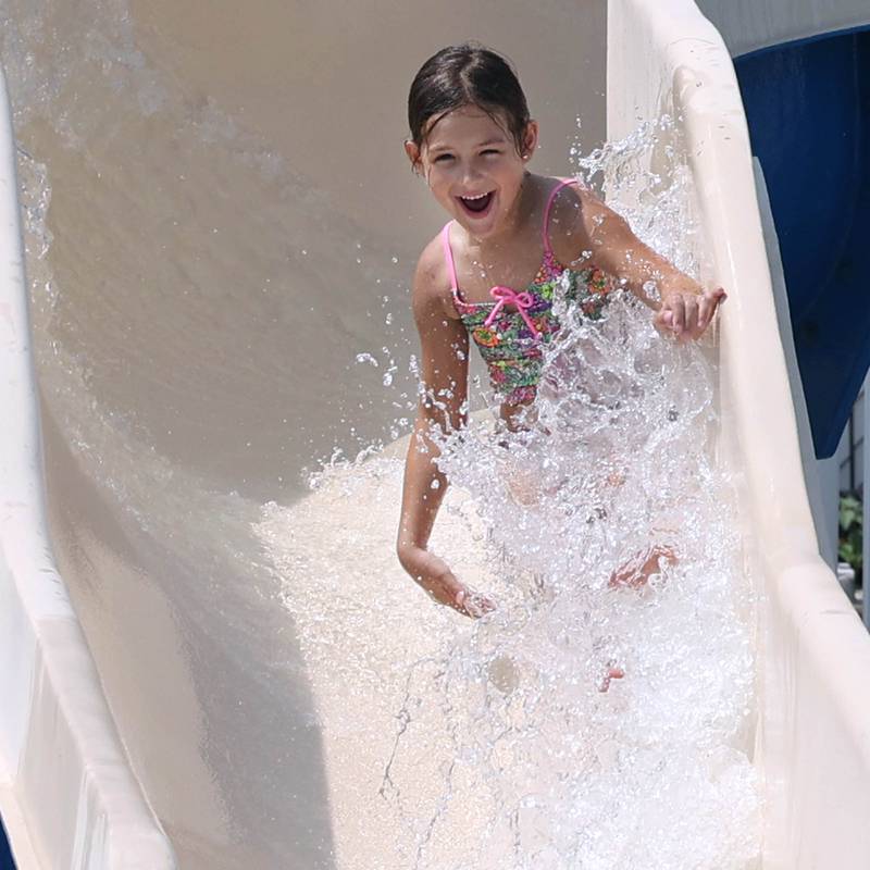 Thora Klimek, 7, from DeKalb, slides down one of the water slides Tuesday, July 25, 2023, at Hopkins Pool in DeKalb.