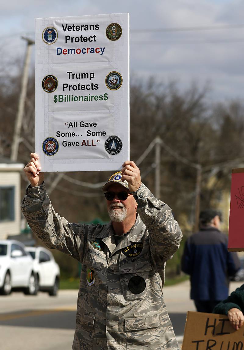 U.S. Air Force veteran Clay Erickson and other protesters line U.S. Route 12 in Richmond to protest their discontent with President Donald Trump and his administration's policies on Saturday, April 19, 2025. Over 100, people took part in the Richmond protest. A second rally was held in Harvard later in the day.