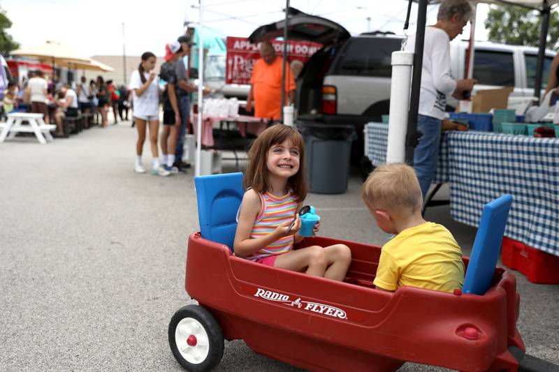 Claire, 5, and Colton Thiess, 2, of Elmhurst enjoy a cool treat at the Elmhurst Farmer’s Market on Wednesday, July 7, 2025 at the market’s new location parking lot of Elmhurst Christian Reformed Church.