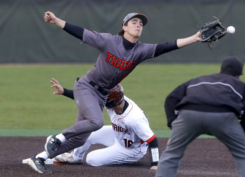 Crystal Lake Central's James Dreher reaches for the ball as McHenry’s Kyle Maness slides into second base during a Fox Valley Conference baseball game on Friday, May 2, 2025, at McHenry High School.