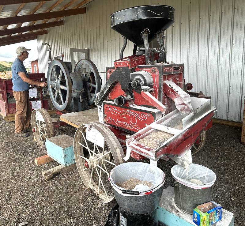 A volunteer runs the antique Fairbanks Morse engine that powers the wheat mill at the Bos Brothers Historical Farm south of Erie on Saturday, July 26, 2025.