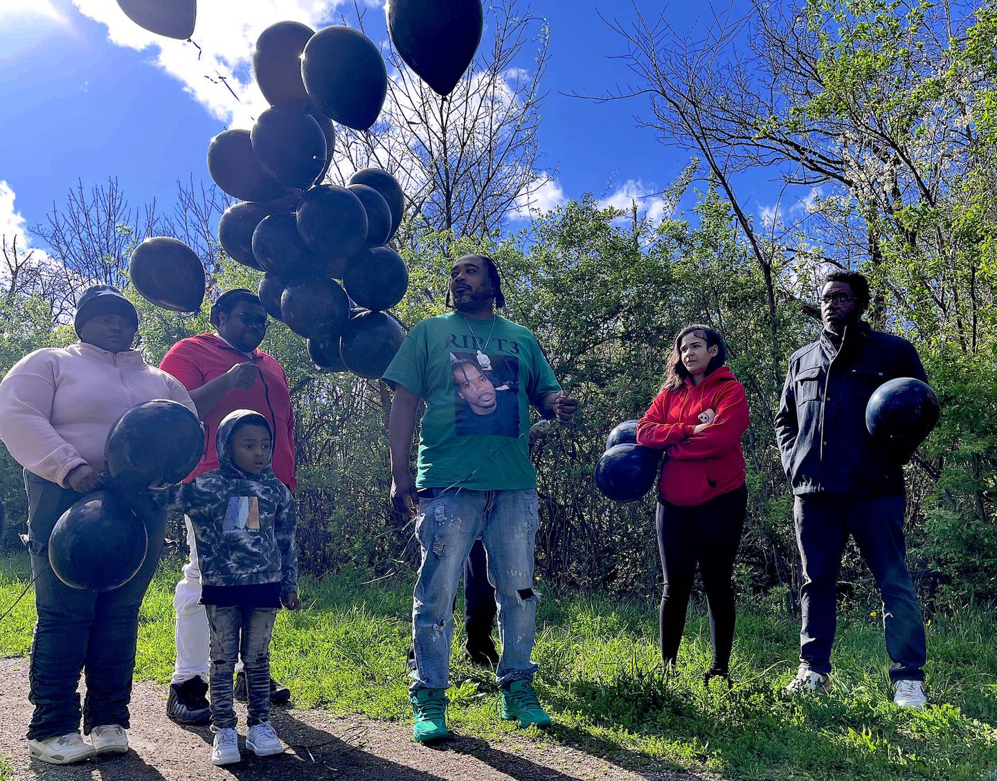 Jennifer Sanders (left), the sister of Terhan Foster Gordon, 36, of Joliet, stands with her brother, Lamont Sanders, and Bryce Epting (center), along with other attendees of a balloon release for Gordon on Saturday, April 18, 2026, in Mokena.
