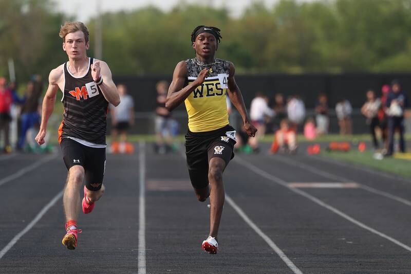 Joliet West’s Billy Bailey Jr takes first ahead of Minooka’s Cael Hiser in the 100 Meters at the Class 3A Minooka Boys Track and Field Sectional on Wednesday, May 17, 2023 in Minooka.