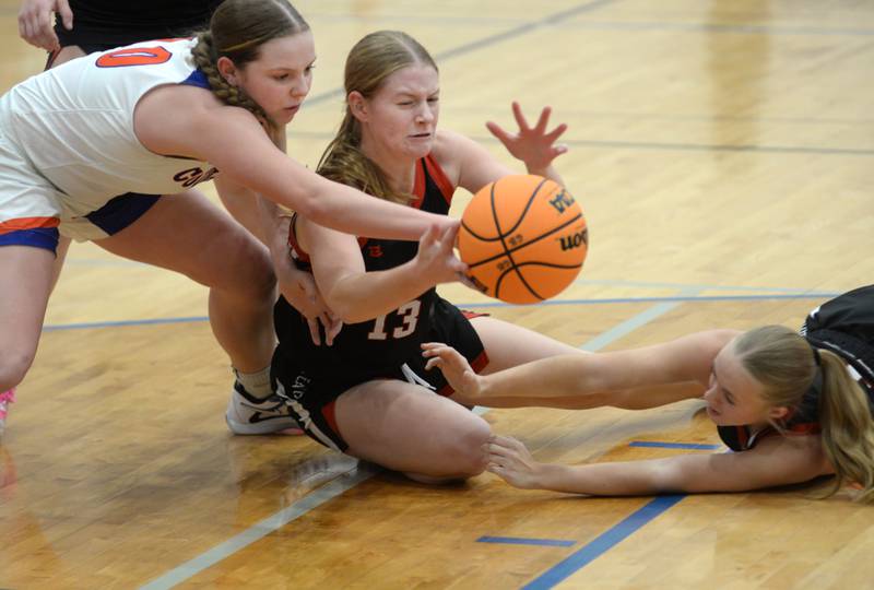 Fulton's Hailey Smither (center) and Belle Curly (right) scramble for a loose ball with Eastland's Izzy Ames (left) on Friday, Dec. 13, 2024 at Eastland High School in Lanark.