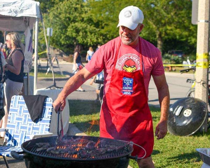 Gregg Lee of Tuxedo Park Czars cooks lamb on Sunday Sep. 1, 2024, during the Cue for a Cause event held in downtown Elmhurst.