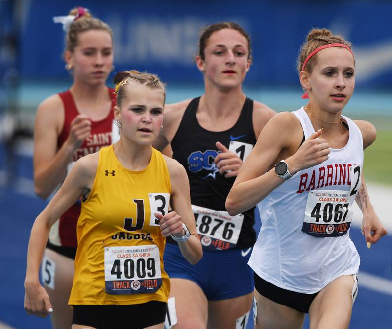 Jacobs’ Lennox Szymonik, left, runs alongside Barrington’s Mia Sirois in the 1,600 while St. Charles North’s Kara Glenn, who won the event, comes up behind them during the Class 3A girls track and field state meet at Eastern Illinois University on Saturday, May 23, 2026 in Charleston.