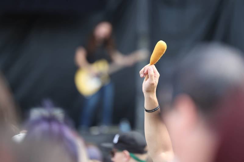 A fan hold up a corn dog as Sincere Engineer, a Chicago area band, plays their song “Corn Dog Sonnet No. 7, on the Roots stage on day one of Riot Fest. Friday, Sept. 17, 2022, in Chicago.