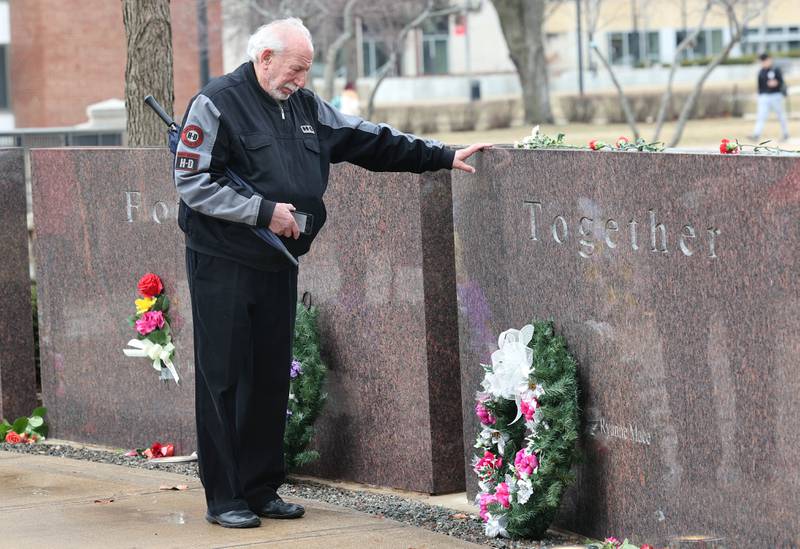 Dan Klein, a former faculty member at Northern Illinois University, pays his respects during a remembrance ceremony Tuesday, Feb. 14, 2023, at the memorial outside Cole Hall at NIU for the victims of the mass shooting in 2008. Tuesday marked the 15th year since the deadly shooting took place on campus which took the lives of five people.