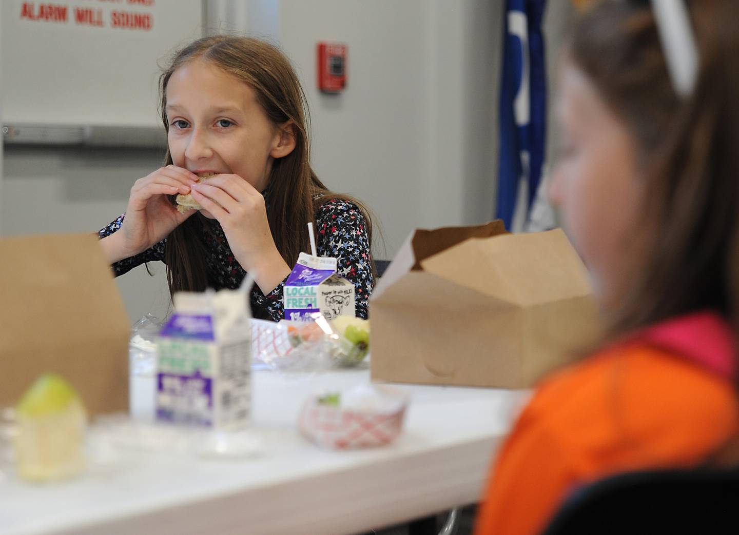 Taylor Carpenter, 12, and her sister Jordyn Carpenter, 8, both of McHenry, eat  lunch Tuesday, June 7, 2022, at the McHenry Public Library, 809 Front St. in McHenry, during the library's free summer lunches for kids program.