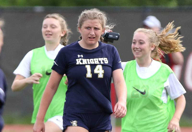 IC Catholic Prep's Lucy Russ walks off the field as Pleasant Plains players celebrate their 1-0 win in the IHSA Class 1A state girls soccer third place game Saturday, May 27, 2023, at North Central College in Naperville.