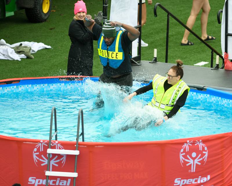 Two members of the Sycamore police department jump in the pool during the Polar Plunge event on Saturday Feb. 21, 2026, held at Huskie Stadium in DeKalb.