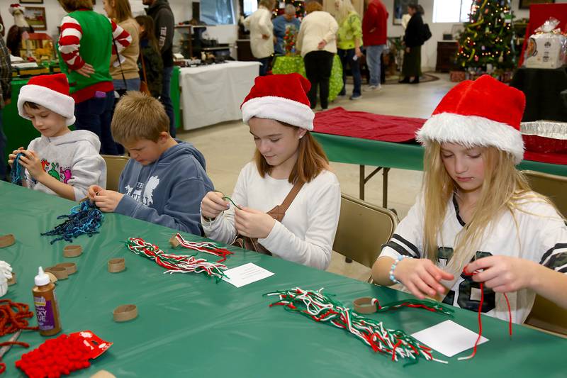 Jacob Urbanek, Jackson Anastos, Cameron Anastos and Mila Ciraelbach make Christmas decorations at the Kendall County Historical Society’s Annual Christmas at the Lyon Farm on Sunday, Dec. 8, 2024 in Yorkville.