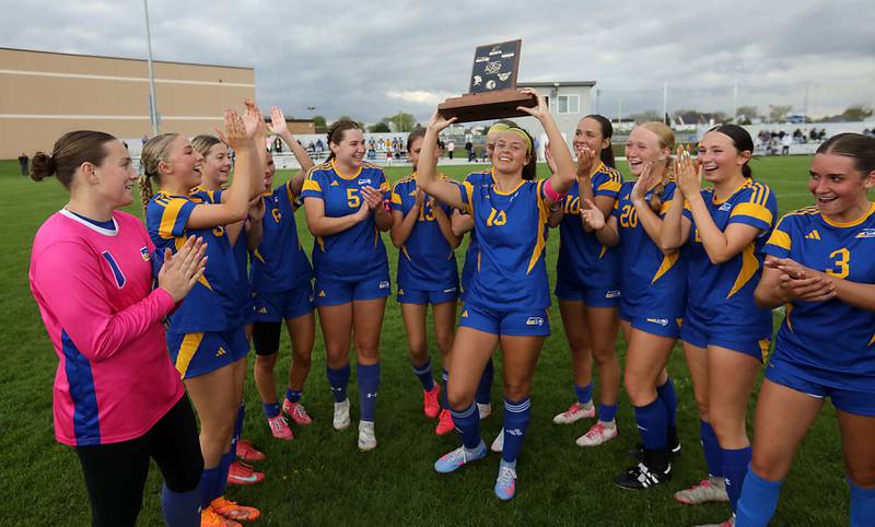 Johnsburg's Lauren McQuiston raise the conference championship trophy after Johnsburg defeated Harvard in a Kishwaukee River Conference soccer match on Wednesday, April 27, 2026, at Johnsburg High School.