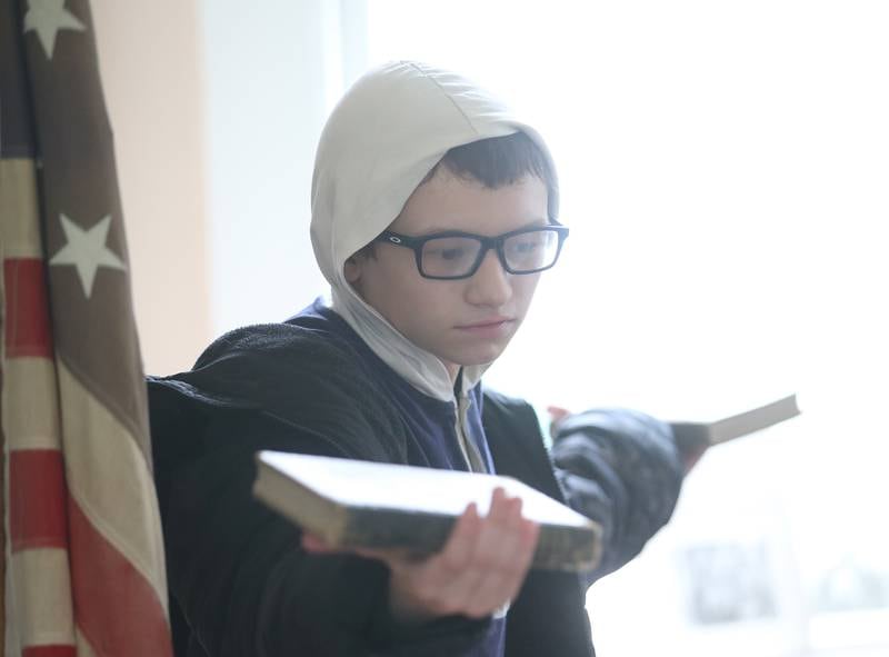 Cole Santee, a student with the Bureau County Special Schools BEST Program, holds books in both hands during a field trip to Aitken School on Tuesday, May 20, 2025, at the La Salle County Historical Society in Utica. Aitken School is a one-room schoolhouse located on the historical society's campus. If a child was being disrespectful in the 1800s, they would extend their arms out and hold books in their hands.