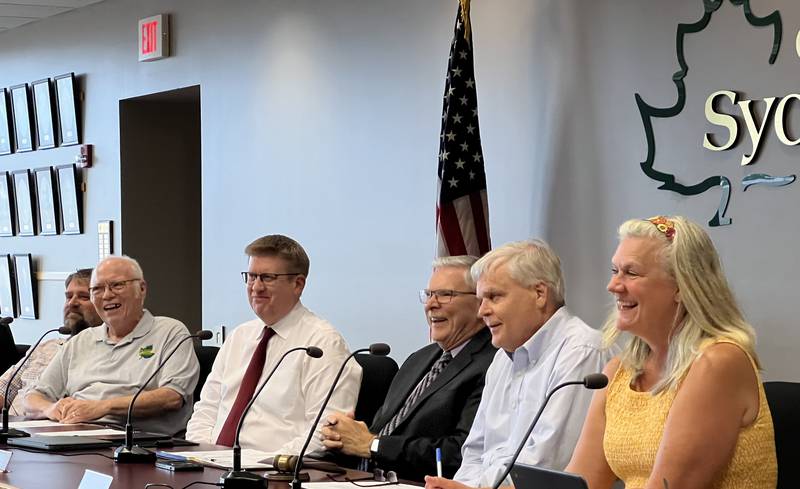 Second Ward Alderpersons Pete Paulsen and Chuck Stowe, left, Sycamore City Manager Michael Hall, city attorney Keith Foster, Sycamore Mayor Steve Braser, and City Clerk Mary Kalk smile during the Aug. 21, 2023 Sycamore City Council meeting.