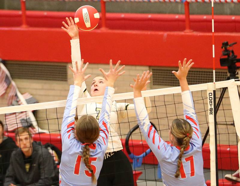 Sycamore's Laci Neece spikes the ball between Ottawa's Addison Duggan and Olivia Evola on Thursday, Oct. 12, 2023 at Kingman Gym.
