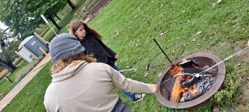 The Marshall-Putnam 4-H Federation Club held a family fund day at the Putnam County Conservation Area in McNabb on Oct. 14. Daphne Heeley (back facing camera) and Gwen Heeley of the Saratoga Leadaways cooking hot dogs over the fire.