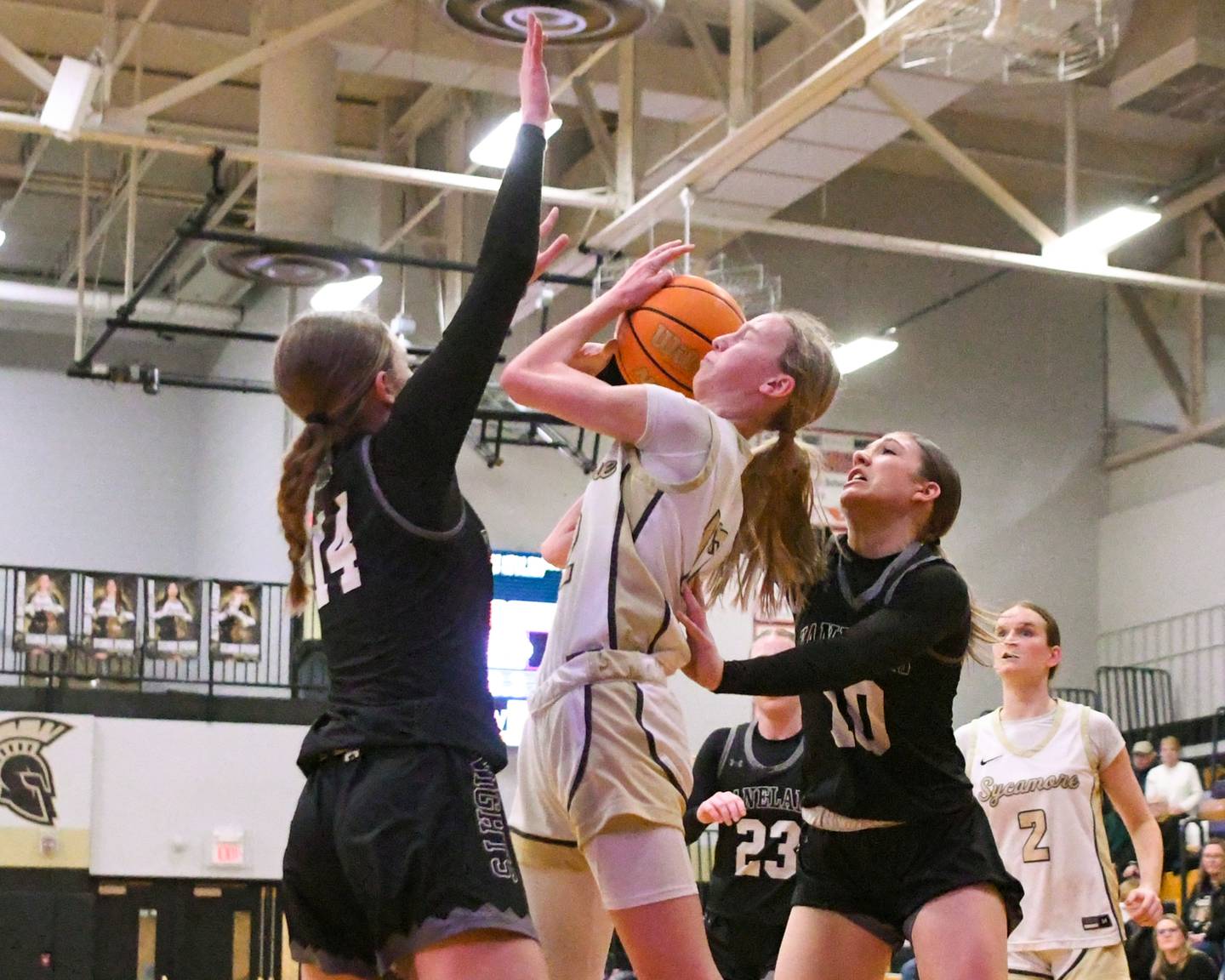 Sycamore's Sadie Lang, center gets fouled while taking a shot during the game as Kaneland's Grace Brunscheen, left and teammate Kalie Brown try to defender her on Monday Feb. 10, 2025, held at Sycamore High School.