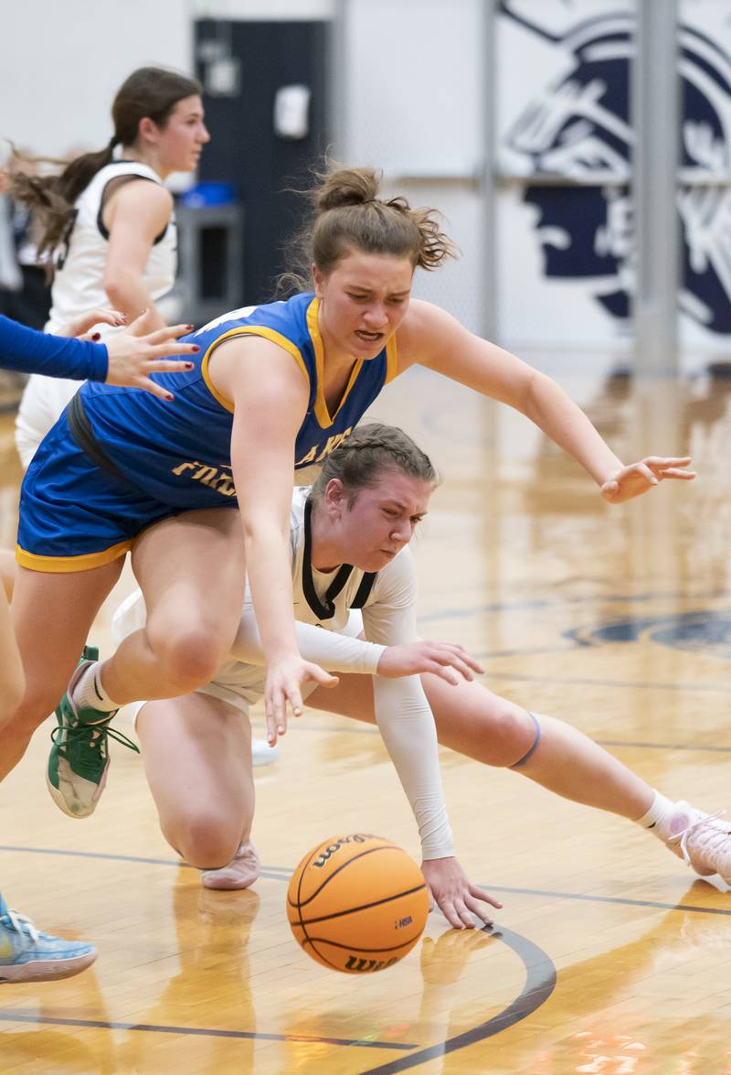 Lake Forest's Ryan Rice and Cary-Grove's Ellie Mjaanes battle for a loose ball during the Class 3A Cary-Grove Regional Girls Basketball Championship game on Thursday, February 20, 2025 in Cary. Ryan Rayburn for Shaw Local