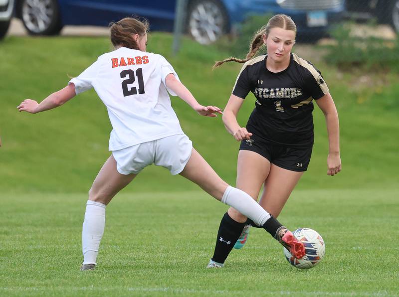 DeKalb's Quinn McLane tries to kick the ball away from Sycamore's Elizabeth Goff Thursday, May 7, 2026, during their game at Sycamore High School.