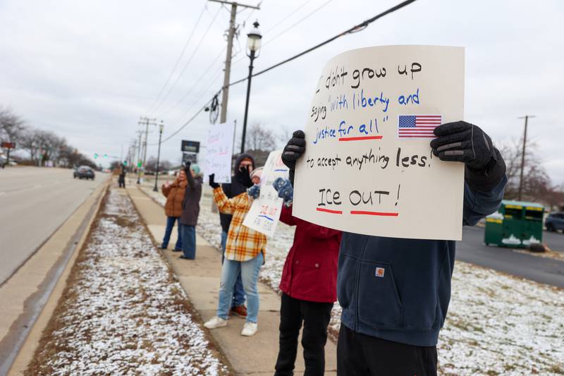 Protesters hold signs along IL Route 102 following an ICE Out for Good protest and vigil at The Grow Center in Bourbonnais on Sunday, Jan. 11, 2026.