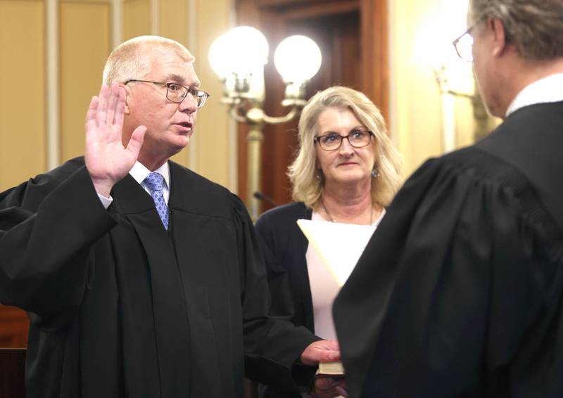 Judge Philip Montgomery is sworn in as a circuit court judge for the 23rd Judicial Circuit Court by Judge Bradley Waller as his wife Lisa Montgomery holds the bible Friday, July 15, 2022, at the DeKalb County Courthouse in Sycamore.