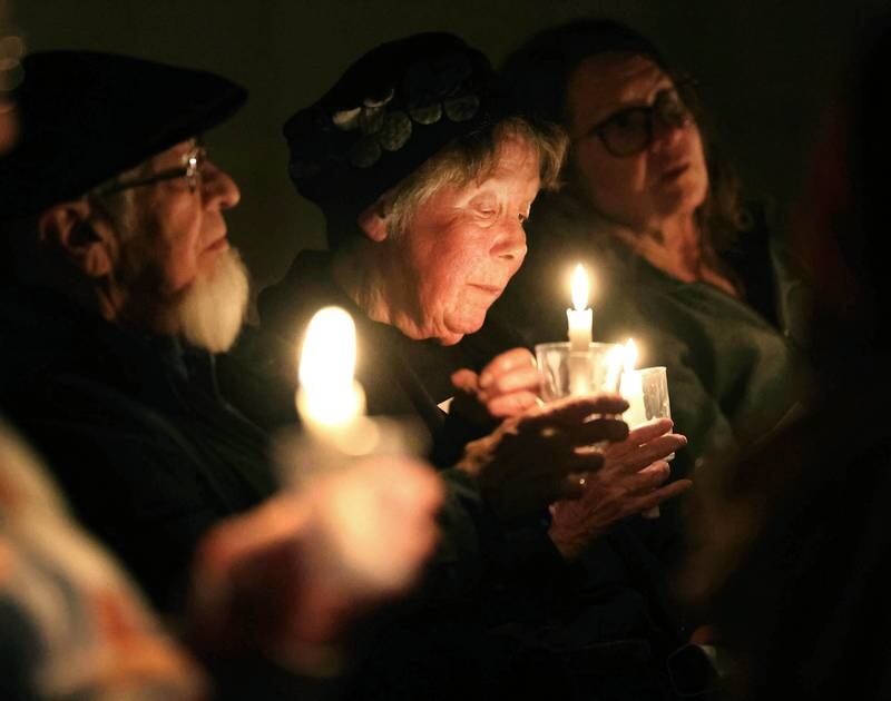 Visitors sit in quiet reflection while holding their candles Monday, Feb. 2, 2026, during the Vigil for Peace at the First Congregational United Church Of Christ in DeKalb. The vigil is being held in remembrance of those lost in recent ICE related shootings and to show solidarity with the people of Minnesota.