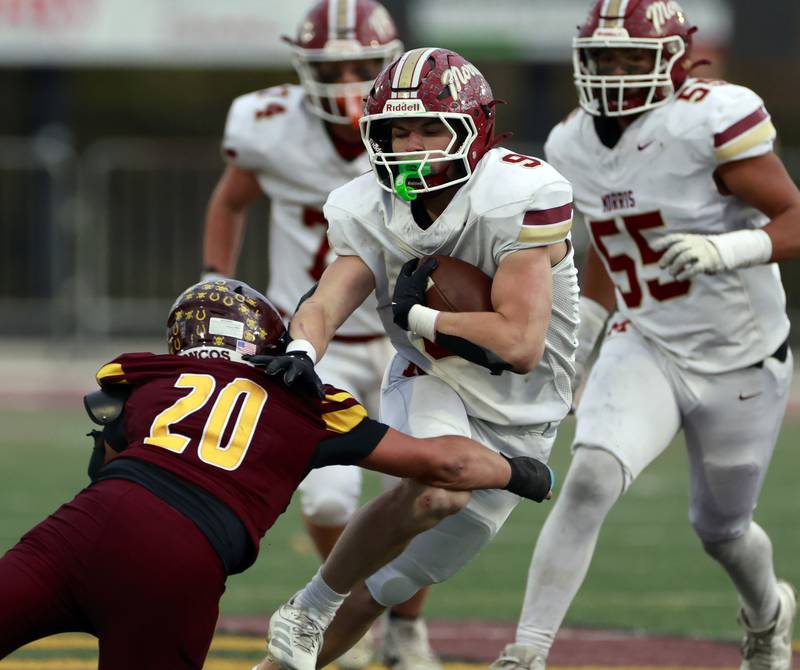 Morris' Caeden Curran (9) stiff arms Montini's Orlando Greco (20) during the IHSA Class 4A semifinals football playoff game Saturday, Nov. 22, 2025 in Lombard.