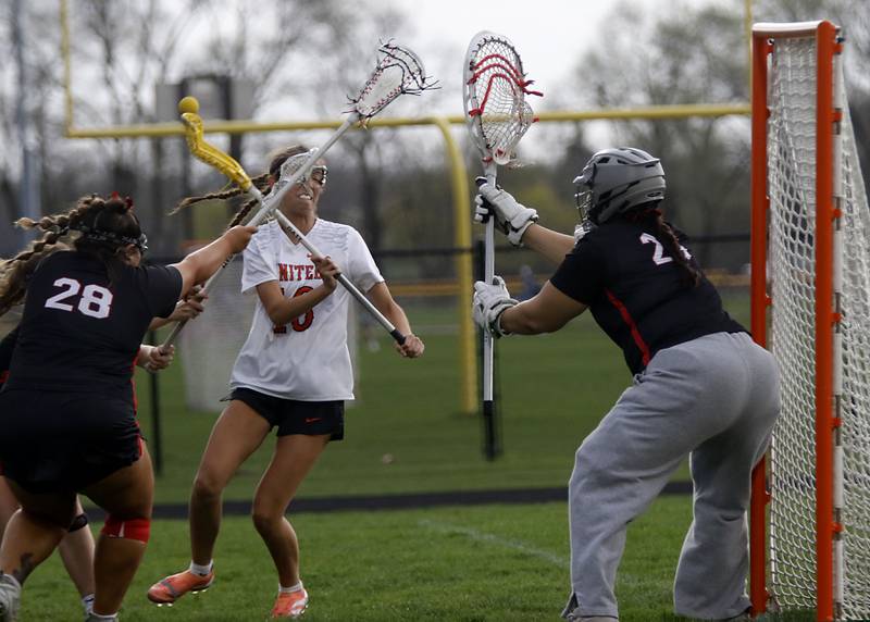 Crystal Lake Central co-op's Sydney Cruz takes a shot at the goal betweenHuntley's Payton Turk (left) and McKenna Wiley during a Fox Valley Conference girls lacrosse match on Friday, April 17, 2026, at Crystal Lake Central High School.