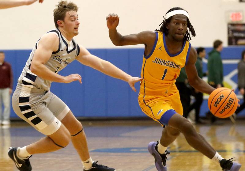 Johnsburg's Jarrel Albea (left) drives to the lane as Cary-Grove's Brandon Freund tries to guard him during a Johnsburg Thanksgiving Tournament boys basketball game on Monday, Nov. 24, 2025, at Johnsburg High School.