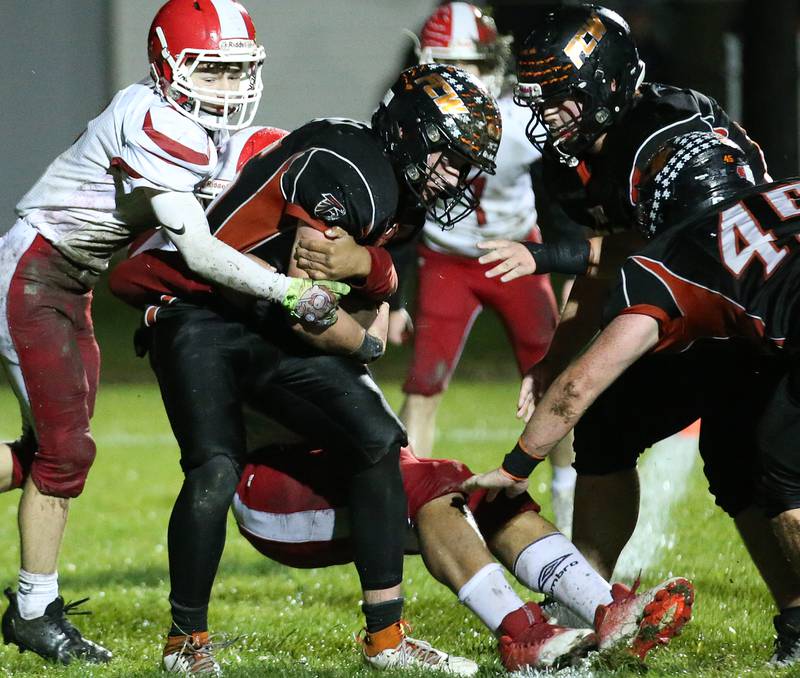 Flanagan-Cornell/Woodland's Kesler Collins is taken down from behind by South Beloit's Chase Herrington during the first round of the 8-man football playoffs on Friday, Oct. 27, 2023 in Flanagan.