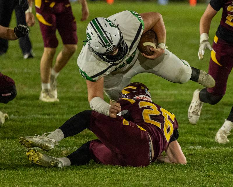 Jake Wilkey (65) of Dwight jumps over Carter Blair (26) of Stockton whilst running ball on Saturday, November 15, 2025 at John O' Boyle Field in Stockton.
