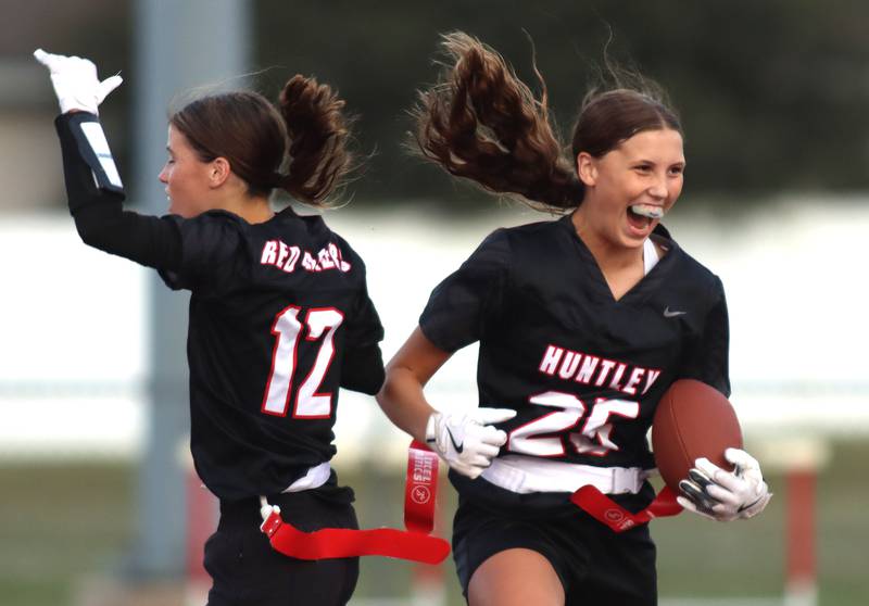 Huntley’s  Evelyn Freundt, right, and Aubrina Adamik, left, celebrate a Freundt touchdown against McHenry in varsity flag football at Huntley High School in Huntley on Tuesday, Sept. 9, 2025.