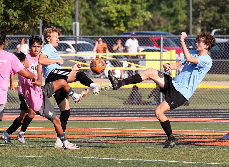 Two Sycamore players kick the ball Monday, July 14, 2025, during a summer boys soccer friendly at DeKalb High School.