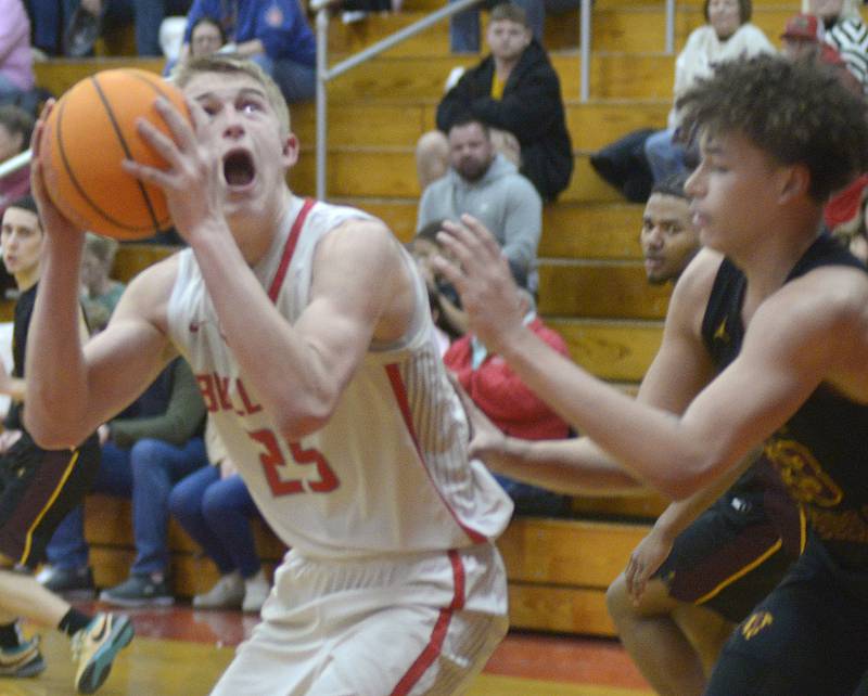 Streator’s Joseph Hoekstra eyes the basket as East Peoria’s Quinton Kitt sets to block during the 1st period Wednesday at Streator.