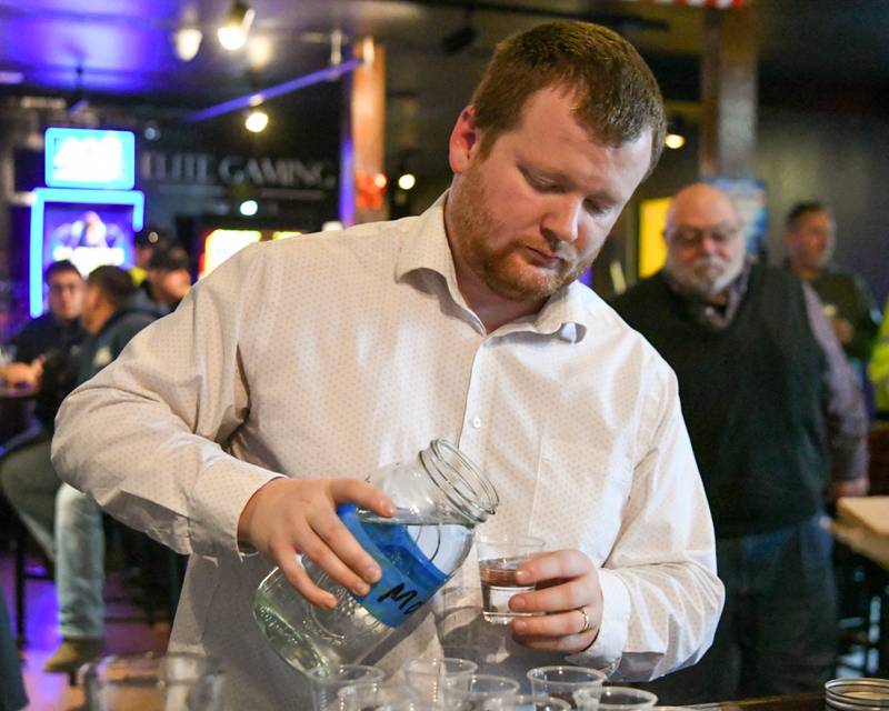 Incoming president of the Kane County Water Association Lucas Smith, Director of public works in Genoa pours water into cups for tasting during the water tasting of KIncoming president of the Kane County Water Association Lucas Smith, Director of public works in Genoa pours water into cups for tasting during the water tasting of Kane County on Thursday Dec. 18, 2025, held at Global Brew Tap House in St. Charles.ane County on Thursday Dec. 18, 2025, held at Global Brew Tap House in St. Charles.
