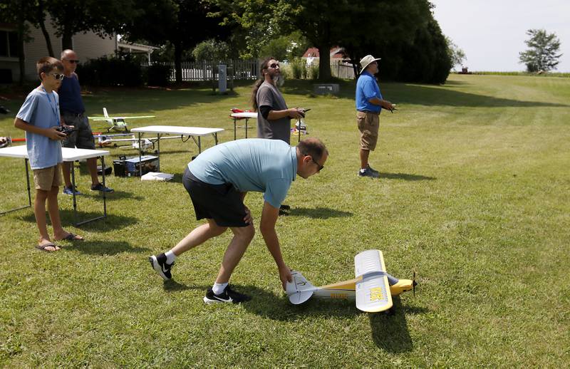 Charlie Missak, 12, watches has dad, Mike, give his plane a push before it takes off on Thursday, Aug. 8, 2024, near Hebron. They're with the Chain-O-Lakes Eagles R/C Club.