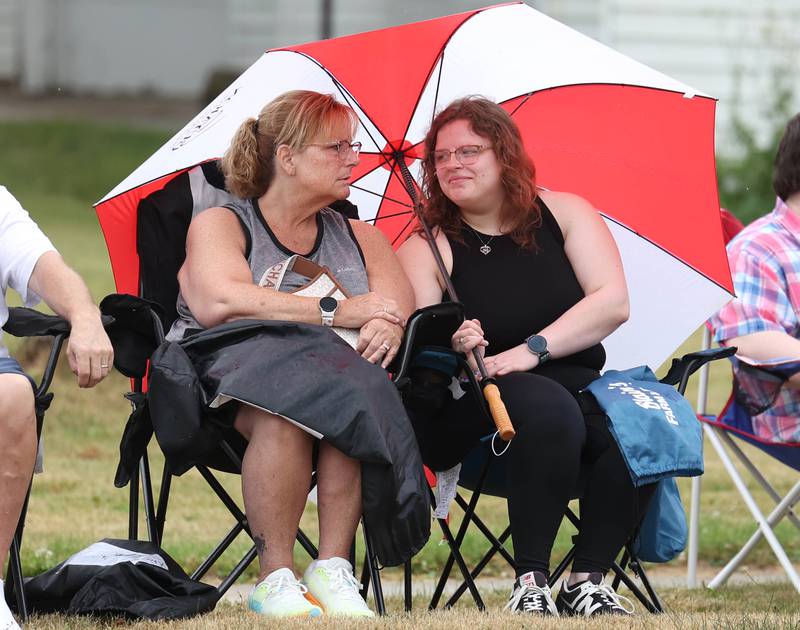 Some parade goers take shelter from the rain as they wait for the start of the festivities Friday, July 4, 2025, during the Fourth of July parade in downtown Kirkland.