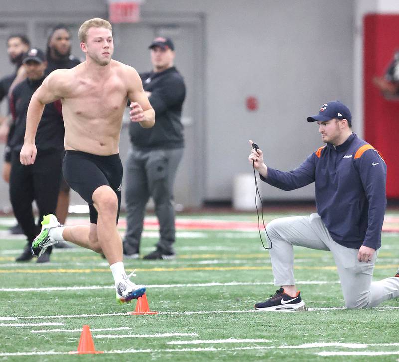 Former Northern Illinois University receiver Cole Tucker, from DeKalb, runs the 40-yard dash as a scout from the Chicago Bears checks his time Thursday, March 23, 2023, during pro day in the Chessick Practice Center at NIU. Several NFL teams had scouts on hand to evaluate players ahead of the upcoming draft.