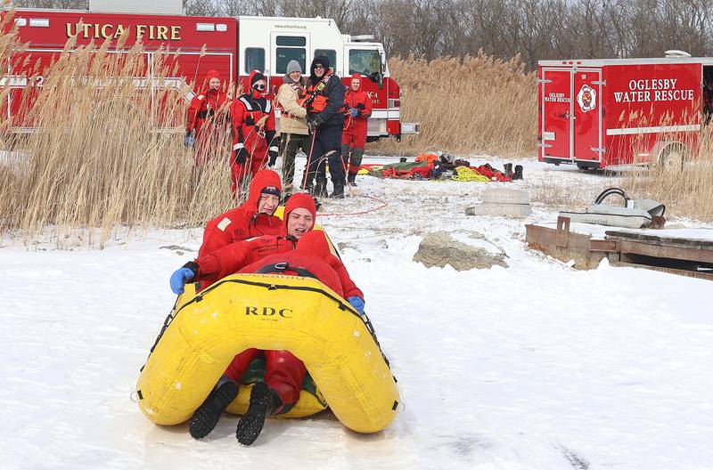 Utica firefighter Troy Opyd and Oglesby firefighter Ben Kolczaski conduct an ice-rescue training drill as Oglesby fire chief Steve Maltas (left) watches while using an inflatable ice raft on a private pond on Sunday, Feb. 1, 2026 south of Utica.
