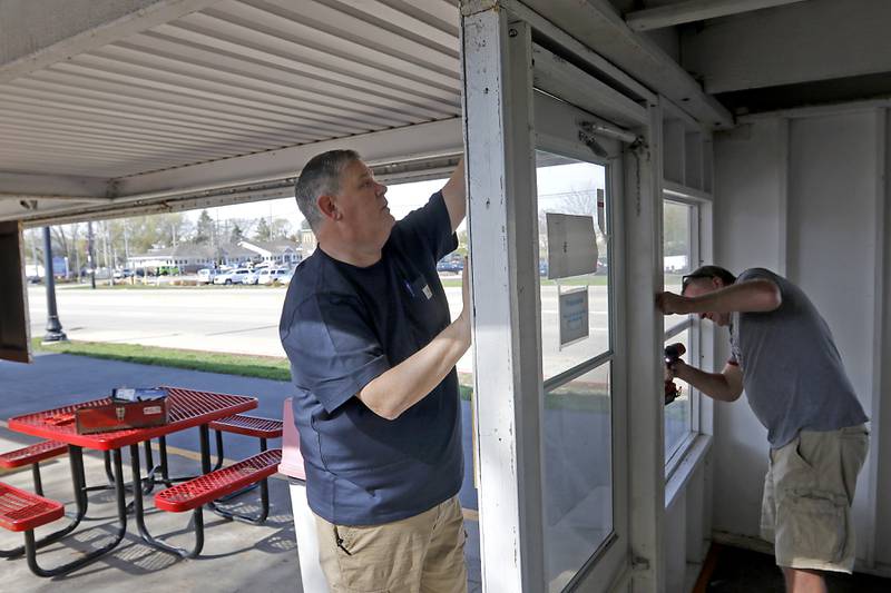 Bill Dunn, who recently purchased the Huntley Dairy Mart on Route 47 in Huntley, works with John Wean to remove the last winter panel from around the restaurant on Friday, April 14, 2023, as they prepare to reopen the Dairy Mart after it closed in February.