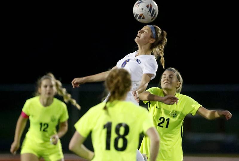 Johnsburg's Elizabeth Smith heads the ball in between Richmond-Burton's Madison Havlicek, (left)  Rachel Mendlik, (center) and Blake Frericks (right) during Kishwaukee River Conference Girls Soccer  Tournament Championship Match Wednesday, May 3, 2023, at Richmond-Burton High School.
