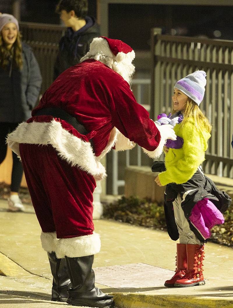 Santa stops to visit a happy young lady Friday, Dec. 6, 2024, at the start of the Dixon Christmas Walk.