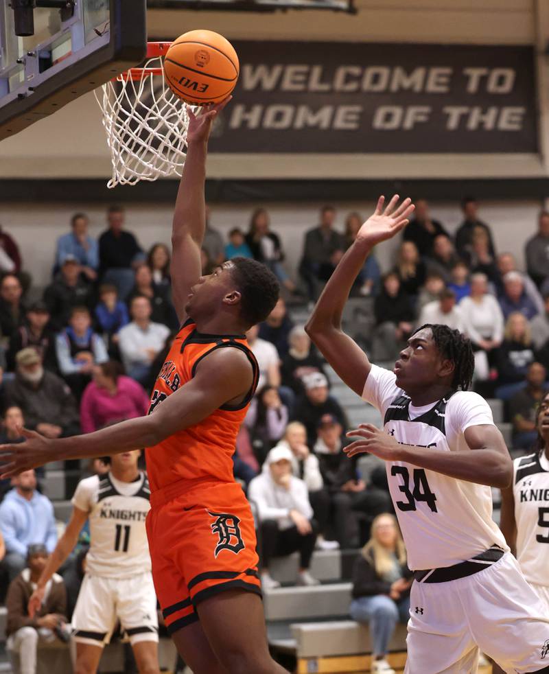 DeKalb's Davon Grant scores a layup in front of Kaneland's Jeffrey Hassan during their game Tuesday, Jan. 28, 2025, at Kaneland High School in Maple Park.