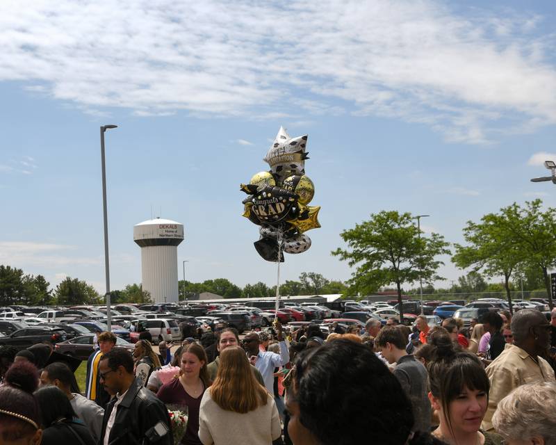 Graduation balloons fly high above the crowd as DeKalb High School graduation attendees wait for their graduates outside the Convocation Center in DeKalb.