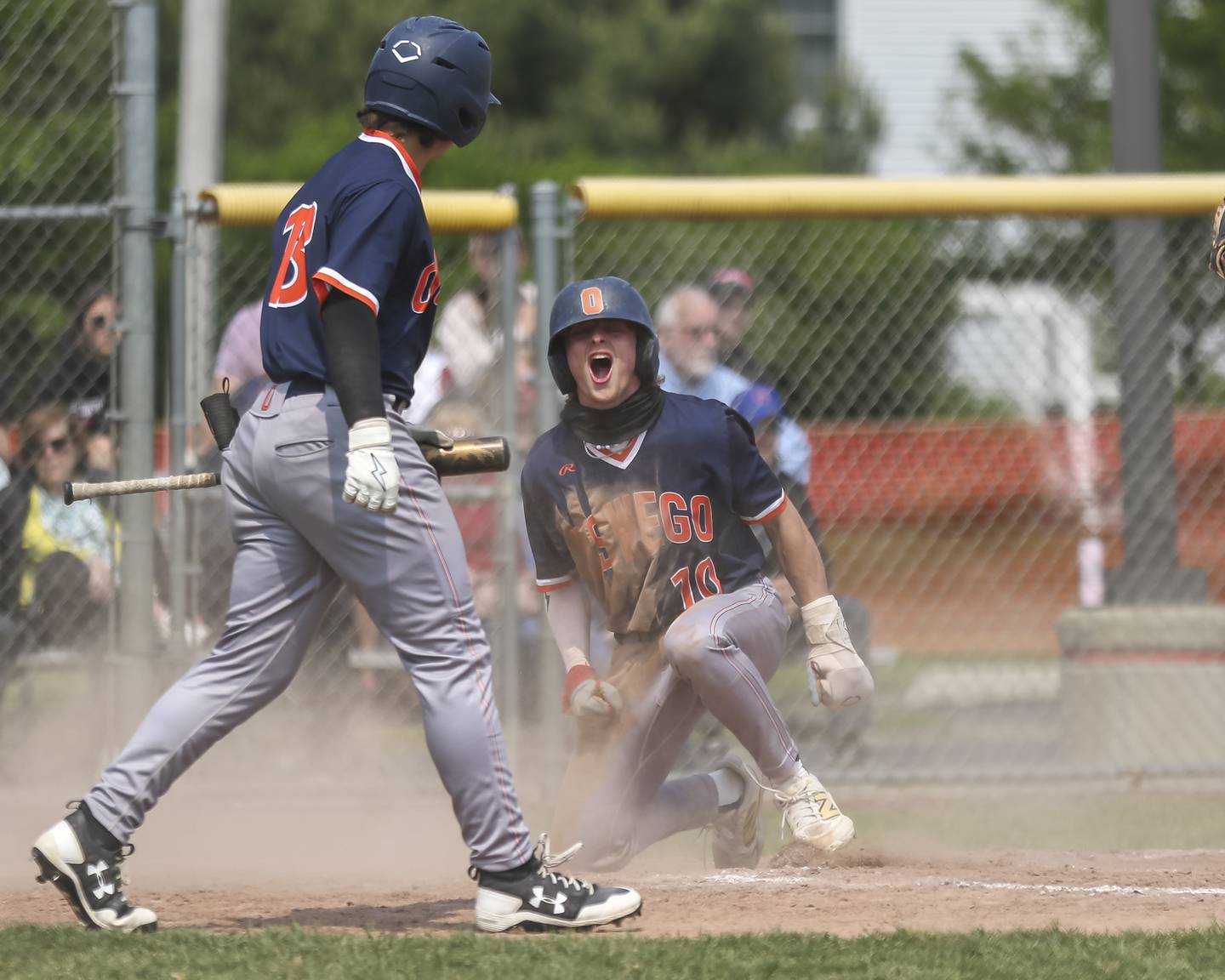 Oswego's TJ Harazin (10) screams out after diving in safe at home during Class 4A Plainfield North Regional final baseball game between Oswego at Plainfield North. Saturday, May 31, 2025 in Plainfield.
