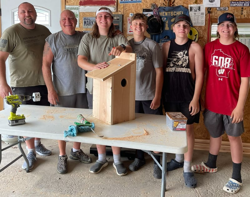Boy Scout Troop 2810 member Will Hentschel with squirrel houses built for his Eagle project