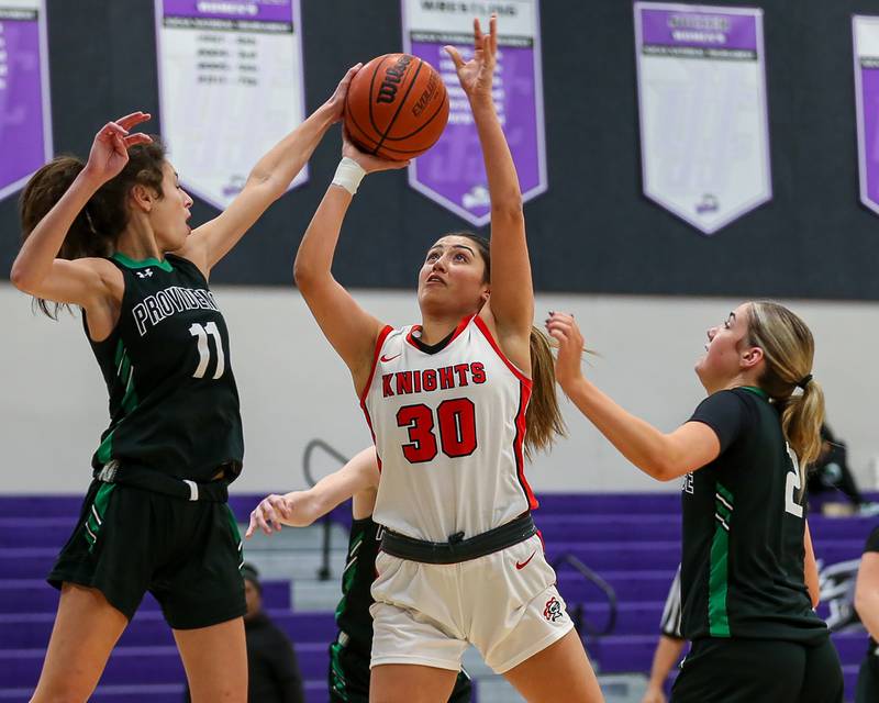 Providence's Bella Morey (11) gets her hand on a shot attempt by Lincoln Way Central's Angelina Panos (30) in the WJOL Tournament Championship game. Nov 18, 2023.