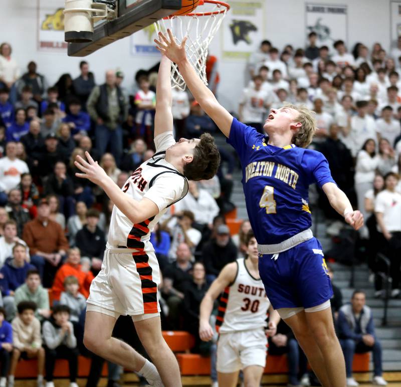 Wheaton Warrenville South's Connor Butler gets the ball to the basket as he’s chased by Wheaton North’s Henry Schlickman during a game on Friday, Feb. 7, 2025 in Wheaton.
